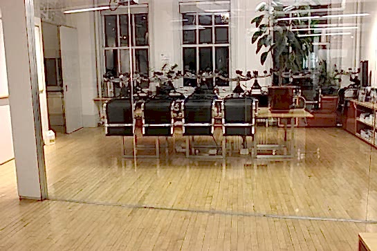 Glass-walled office conference room with wood floors