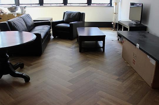 Modern living area with chevron wood flooring